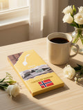 Tastes of Norway melkesjokolade med Oslo-motiv og norsk flagg, pyntet med hvite roser.