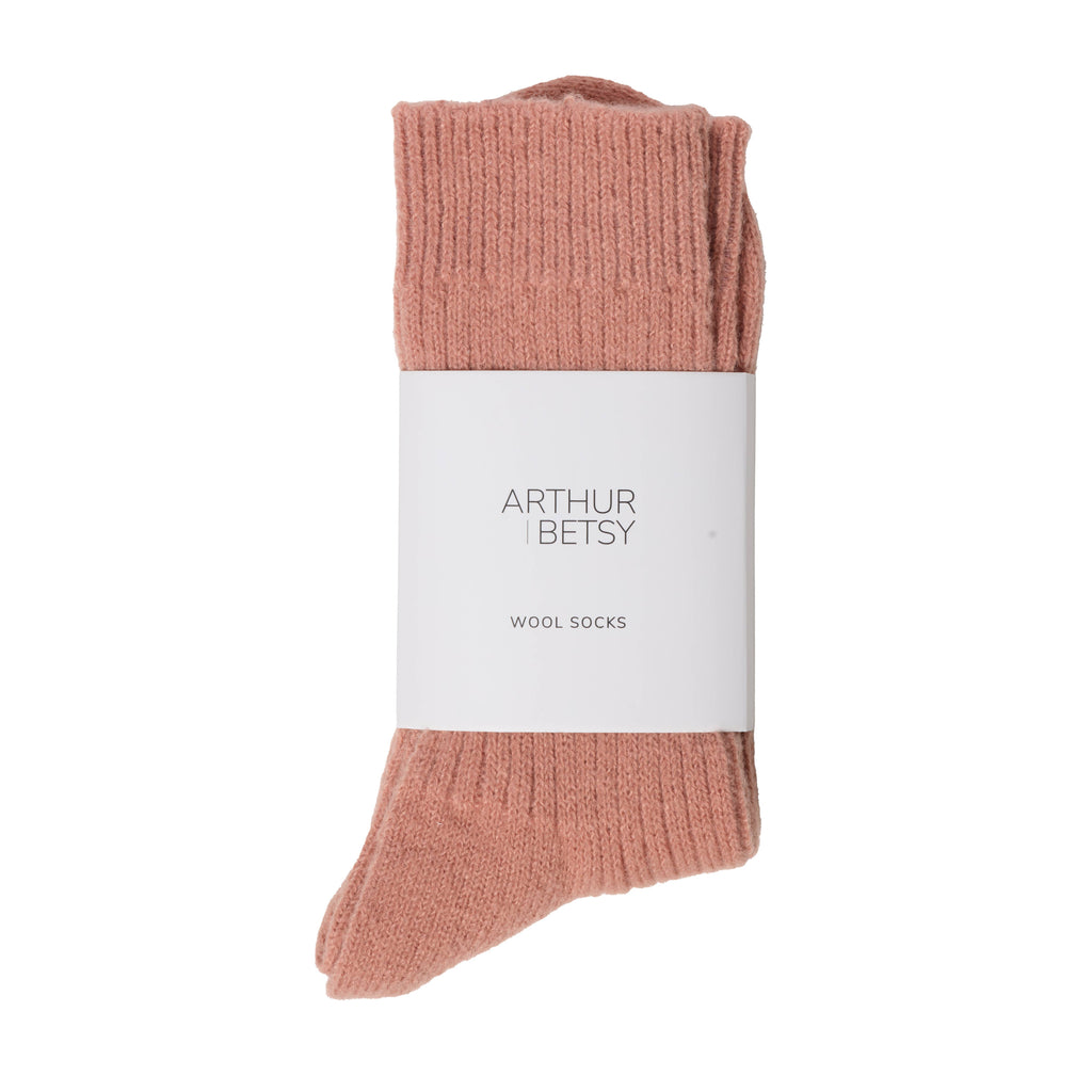 Et par dempet rosa ullsokker i alpakkaull med etikett fra Arthur & Betsy